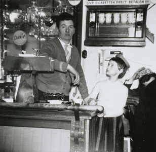 875948 Portret van Antoon van Rijnsoever sr. met Tilly Maas, achter de bar in café Van Rijnsoever (St. Jacobsstraat 7) ...